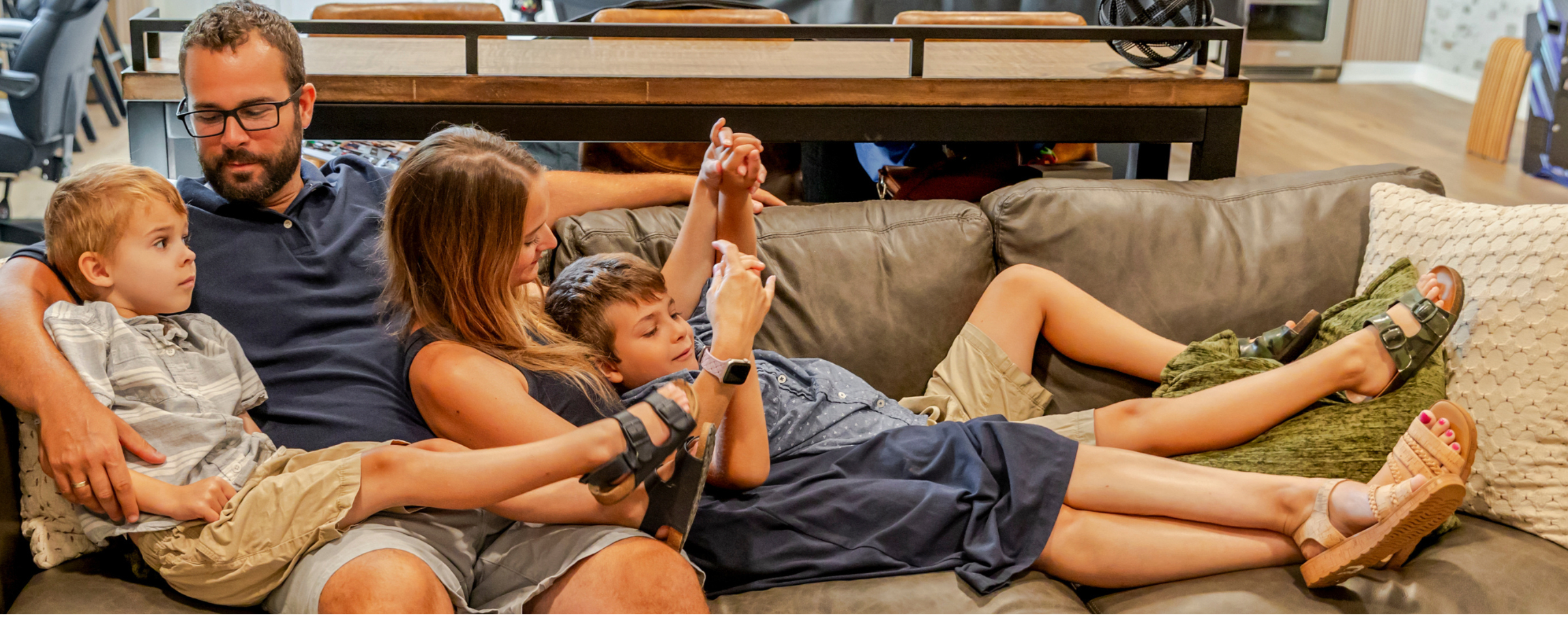 Butter-Fink family: Mom, dad, two young boys cuddling on a couch